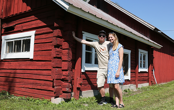 Janina ja Kosti nojaavat vanhan navetan seinään