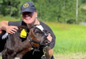 Nainen ja vasikka laitumella